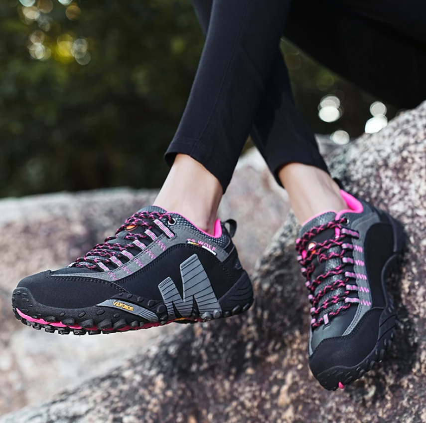 TigleX Flow Unisex-Schuh in Schwarz mit pinken Details – stoßdämpfend, atmungsaktiv und ideal für sportliche Outdoor-Aktivitäten.