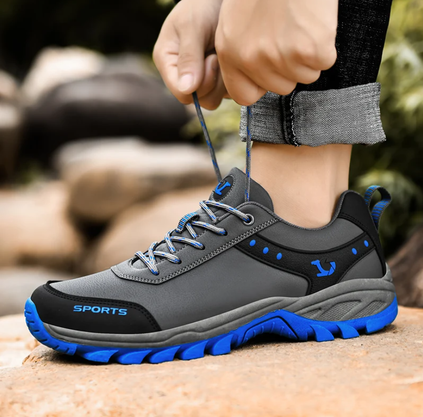 TigleX Lauf- & Wanderschuh in Grau mit blauer Sohle – leicht, atmungsaktiv, ergonomisch geformt und geeignet für sportliches Gehen und Trekking.
