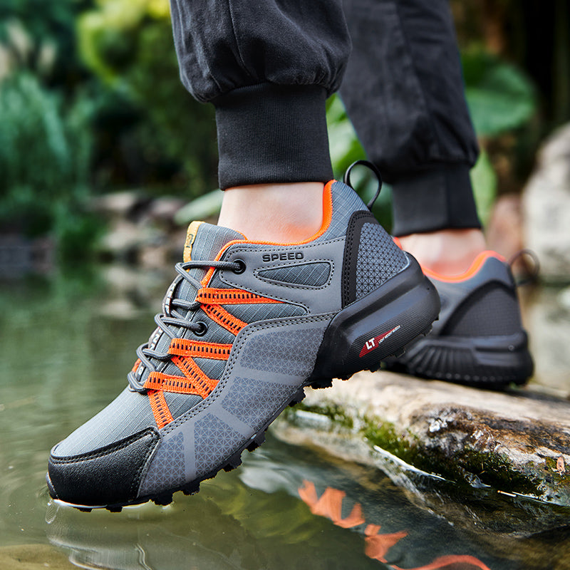 Orthopädischer TigleX Schuh in Schwarz-Grau – aufgenommen in der Natur, mit flexibler, stoßdämpfender Outdoor-Sohle.